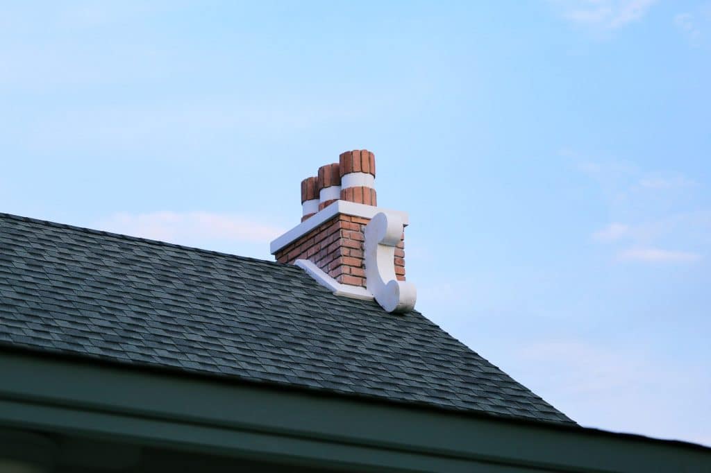 Chimney on house roof closeup blue sky background